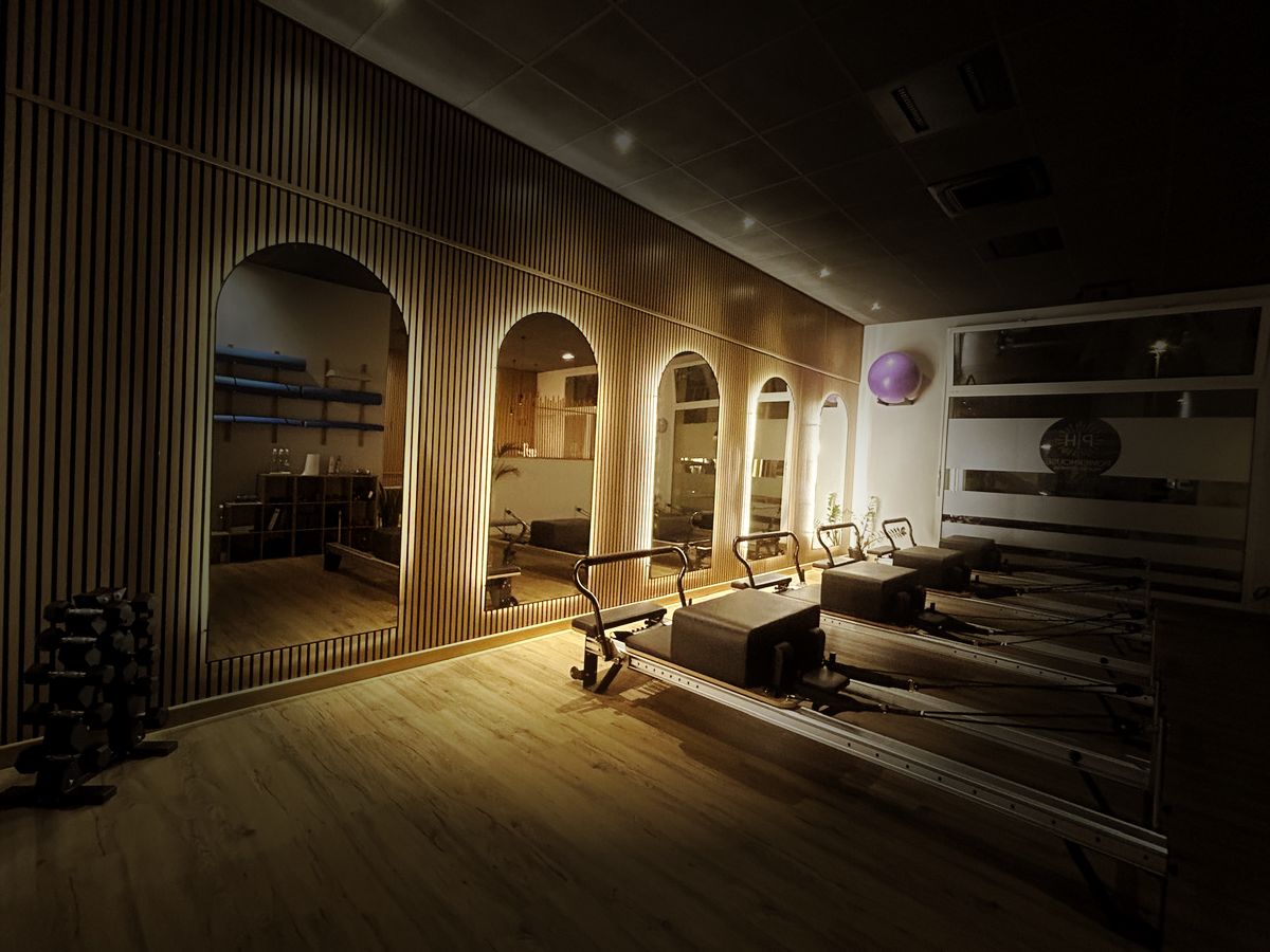 Sala Reformer con quattro reformer davanti agli specchi ad arco